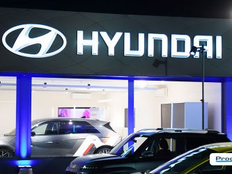 Insegna luminosa Hyundai installata da Progim Sign, valorizzata dall'illuminazione architetturale della concessionaria durante un evento serale.