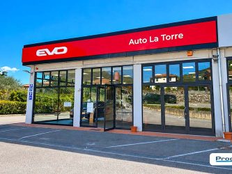 Dettaglio della facciata della concessionaria EVO Auto La Torre con logo EVO e denominazione aziendale sulla fascia rossa, nell’ambito dell’allestimento esterno realizzato da Progim Sign.