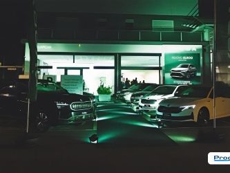 Vista notturna concessionaria Škoda Autocentro Baistrocchi con illuminazione architetturale e percorso di accesso, progetto Progim Sign.