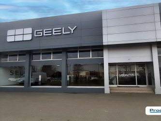 Facciata Geely Locauto Due Novara con insegna istituzionale e ingresso showroom, allestimento corporate identity a cura di Progim Sign.