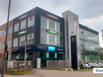 Edificio multipiano K-Monza con insegna luminosa Kawasaki installata da Progim Sign su rivestimento nero