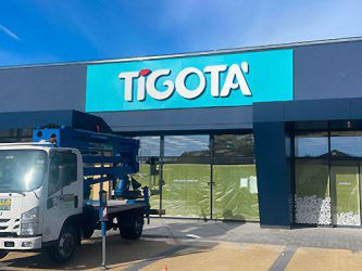 Insegna Tigotà su facciata punto vendita Parabiago durante installazione con mezzo operativo, intervento a cura di Progim Sign.