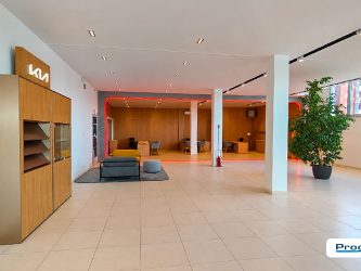 Vista generale dello showroom AutoTorino Cremona con arredi, pareti in legno, area lounge e Infinity Front KIA illuminato.